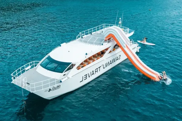 Premium Phi Phi catamaran with water slide and guests swimming in the Andaman Sea