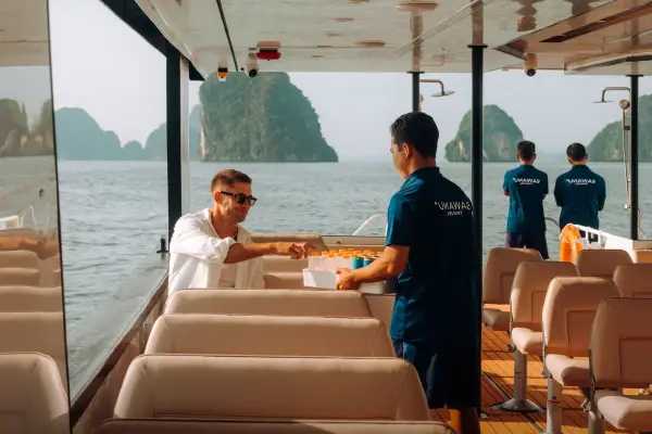Passenger receiving onboard service inside the Phi Phi power catamaran from Phuket