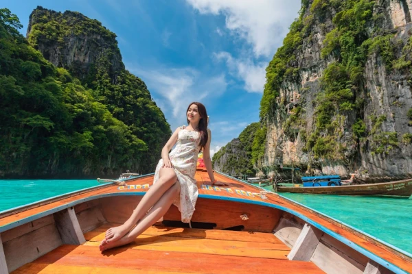 Traveler enjoying a traditional long-tail boat at Pileh Lagoon during a Phi Phi Island tour from Phuket