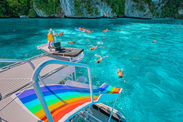 Guests snorkeling beside the speed catamaran during the Phi Phi Island Late Morning Tour