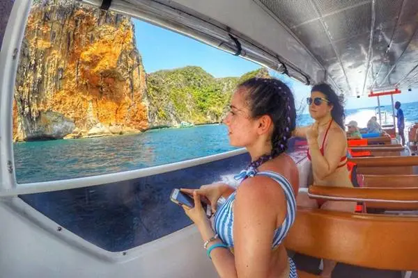 Passengers sightseeing from the covered speed catamaran cabin in the Phi Phi Islands