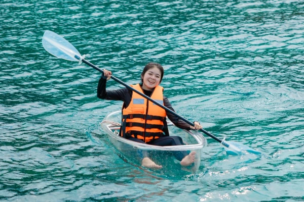 Traveler paddling a clear kayak during the Phi Phi Maya Bay Khai Maiton Island Tour