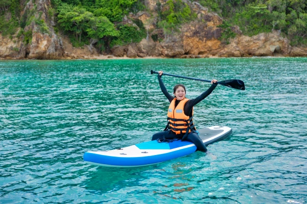 Traveler enjoying paddle boarding during the Maiton Island speed catamaran tour
