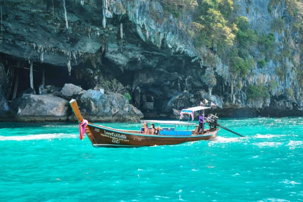 Traditional long-tail boat cruising beside Viking Cave at Phi Phi Leh during the Phi Phi James Bond Krabi 2 day tour