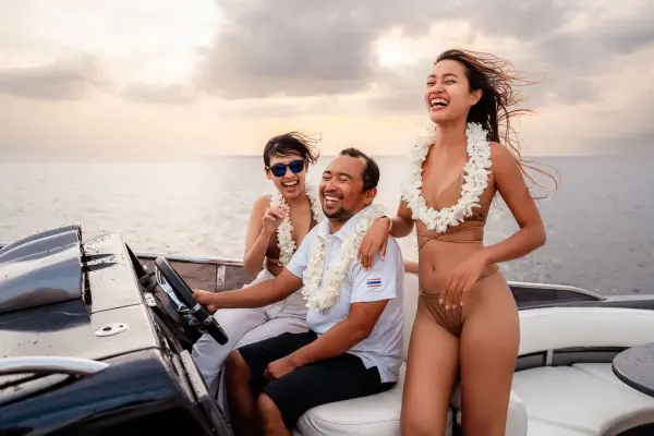 Three guests enjoying the cruise near the helm of the Phi Phi luxury yacht