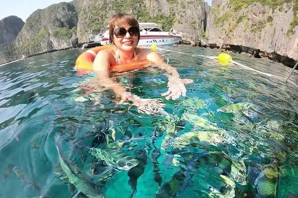 Guest swimming in clear tropical water during the Phi Phi Island Sunset Tour from Phuket