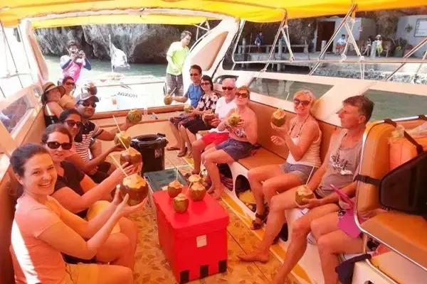 Small-group guests enjoying fresh coconuts aboard the Phi Phi Island Sunset Tour speedboat