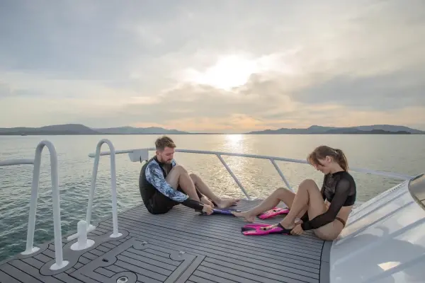 Travelers preparing snorkeling fins on a Phi Phi catamaran tour from Phuket