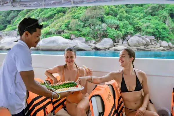 Crew serving fresh fruit to passengers on the Phi Phi Catamaran Tour from Phuket