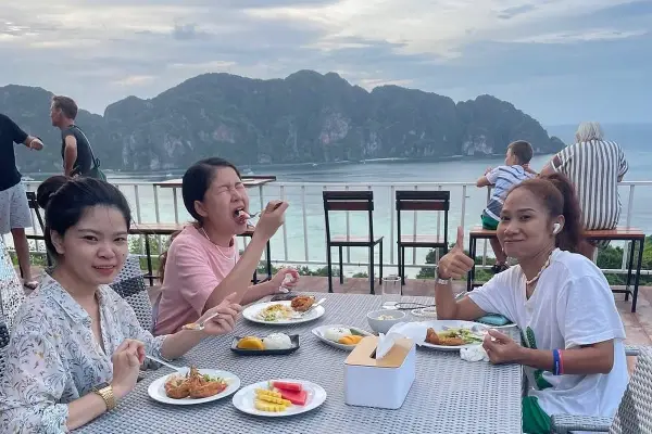 Travelers enjoying lunch at a seaside restaurant on Phi Phi Don Island