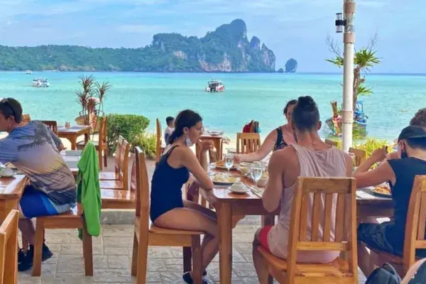 Guests enjoying lunch by the sea at Phi Phi Don during the Phi Phi Island Sunrise Tour from Phuket