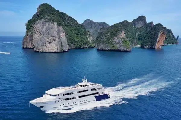 Large cruise boat sailing past the limestone cliffs of the Phi Phi Islands