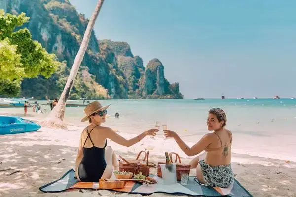 Travelers relaxing on the beach at Phi Phi Don Island during a Phi Phi Island tour from Phuket