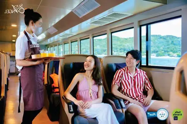 Cruise staff serving refreshments inside the air-conditioned cabin during the Phi Phi Island Tour by Cruise from Phuket