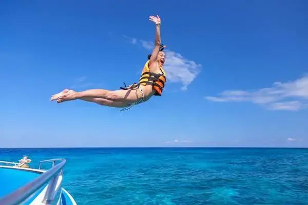 Traveler jumping into the sea during a Phi Phi Island speedboat trip