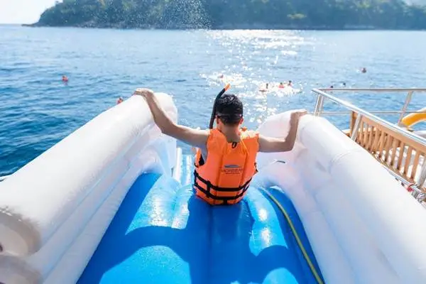 Water slide activity from a luxury catamaran near Naka Island in Phang Nga Bay