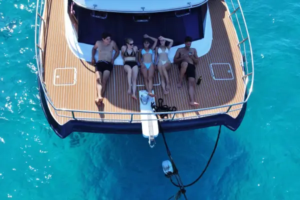 Guests relaxing on the spacious deck of a comfortable catamaran while sailing toward Honeymoon Island