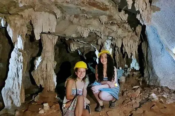 Travelers exploring a limestone cave at Panak Island during a Phang Nga Bay tour from Phuket