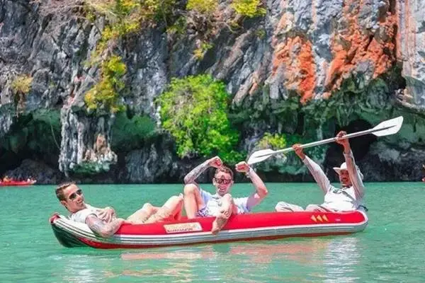 Travelers enjoying sea cave canoeing among limestone cliffs at Hong Island in Phang Nga Bay
