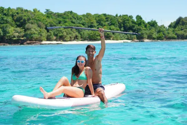 Couple enjoying stand-up paddleboarding near Maiton Island during the Phi Phi luxury catamaran tour