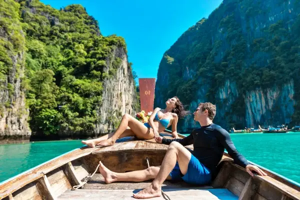 Couple on a traditional longtail boat in Pileh Lagoon at Phi Phi Leh Island