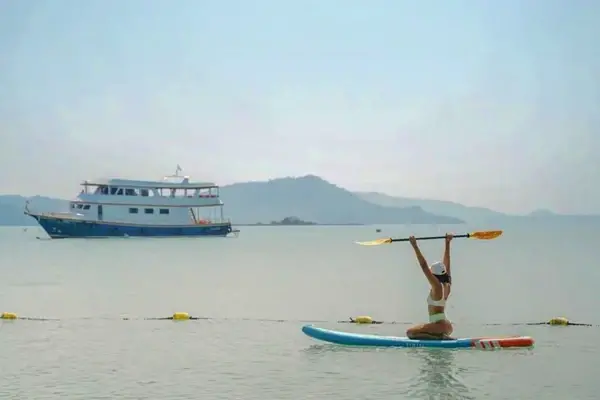 Paddleboarding during the James Bond Island Afternoon Tour from Phuket with the escort boat in Phang Nga Bay