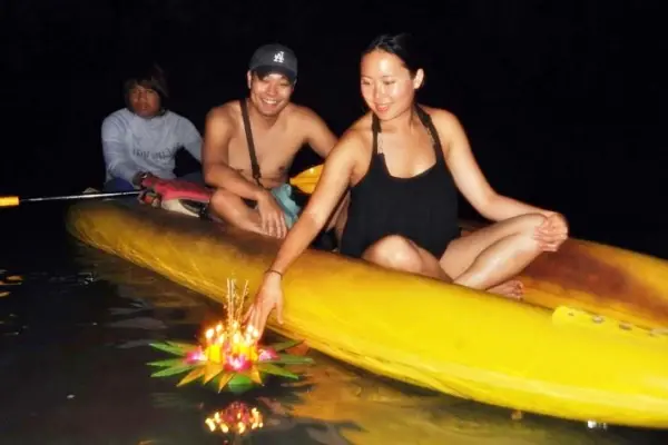 Guest floating a Krathong from a canoe during the James Bond Island Afternoon Tour from Phuket