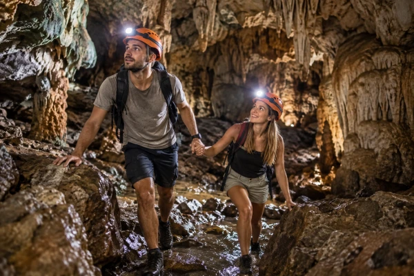 European couple exploring a limestone cave in Phang Nga Bay during the James Bond Island Sunrise Tour from Phuket