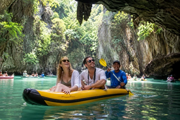 European couple canoeing through limestone caves and a hidden lagoon at Hong Island during the James Bond Island Sunrise Tour from Phuket