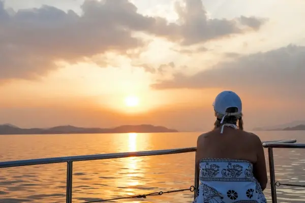 Traveler watching the sunset from the big boat during a Phang Nga Bay evening tour