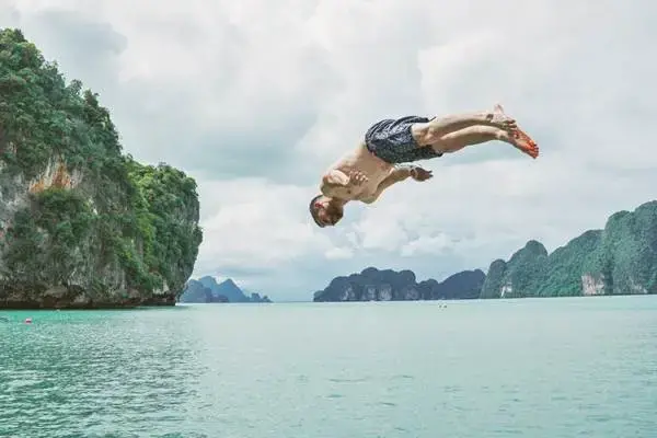 Guest jumping into the sea in Phang Nga Bay during the James Bond Island Sunset Plankton Tour