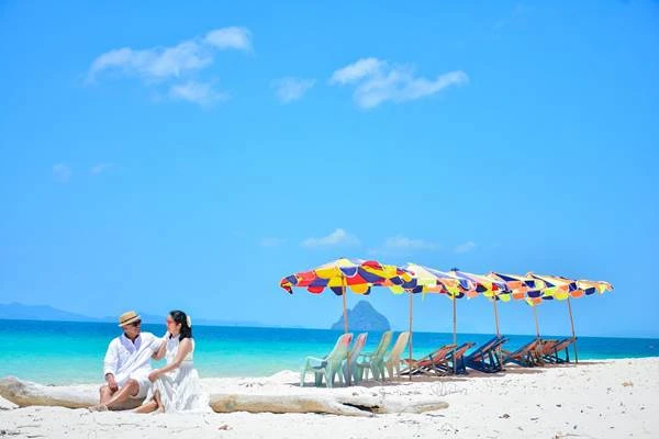 Couple relaxing on the white sand beach at Khai Island during the James Bond Island tour from Phuket