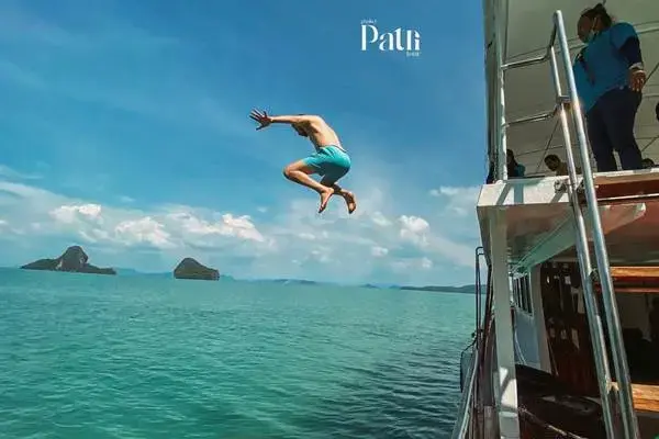 Guest jumping into the sea from the big boat during a James Bond Island Tour from Phuket