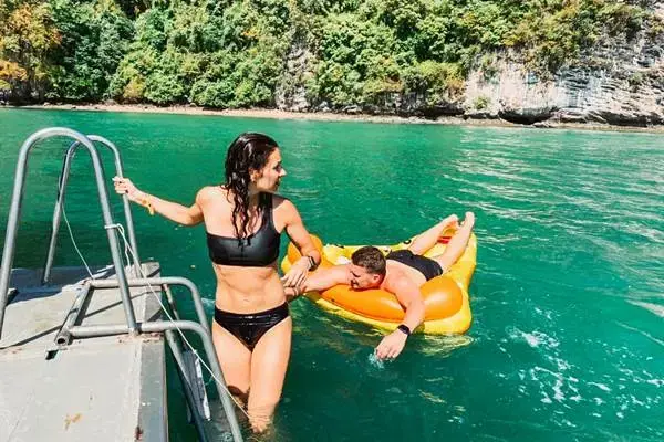 Tourist swimming and relaxing beside the big boat during a James Bond Island Tour from Phuket
