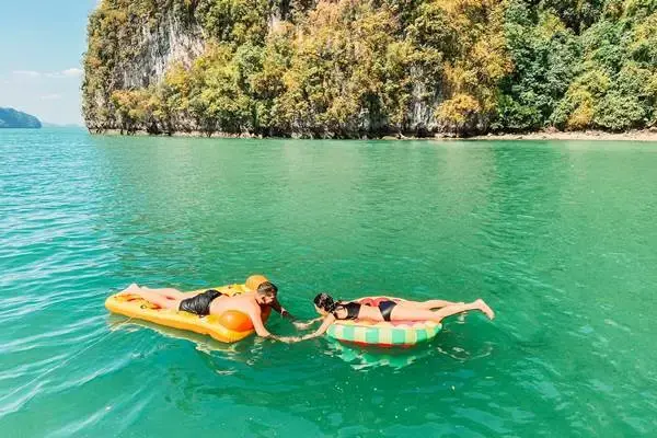 Guests relaxing on floating mats in Phang Nga Bay during the James Bond Island Big Boat Tour