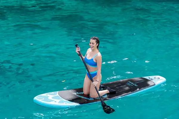 Traveler paddleboarding in clear turquoise water during a Phi Phi Island tour from Phuket