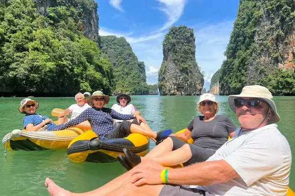 Tourists canoeing among limestone cliffs on the James Bond Island Tour from Phuket