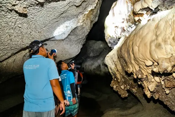 Tourists exploring a limestone cave in Phang Nga Bay during the James Bond Island Tour from Phuket