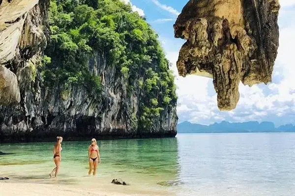 Tourists swimming by a limestone beach during the James Bond Island Tour from Phuket