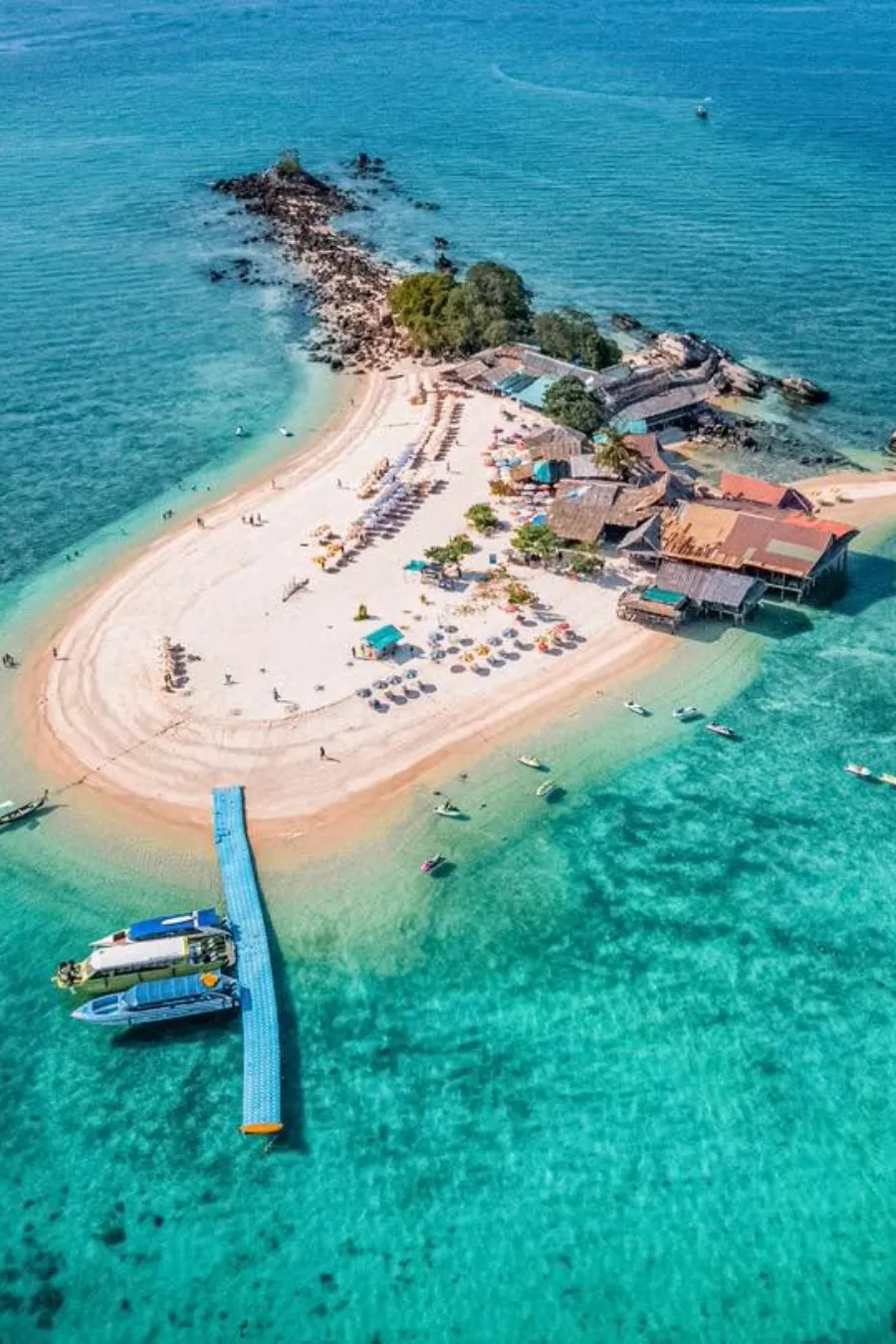 Aerial view of Khai Island's sandy beach, turquoise water and beach umbrellas near Phuket
