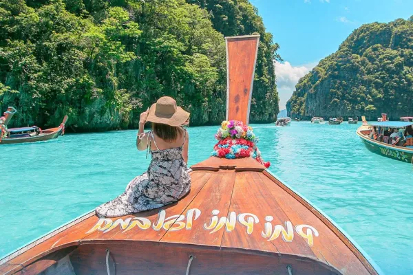Traditional Thai longtail boat surrounded by turquoise water and limestone cliffs at the Phi Phi Islands