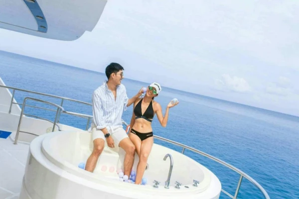 Couple relaxing in the outdoor jacuzzi aboard a luxury catamaran with panoramic Andaman Sea views near Phuket