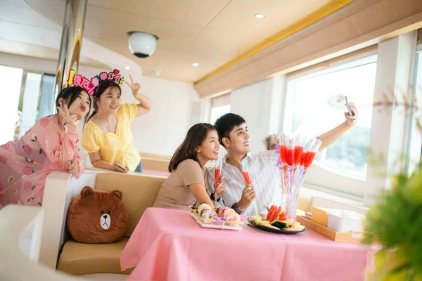 Friends enjoying drinks and taking photos inside the luxury catamaran lounge during a Phi Phi Island tour from Phuket