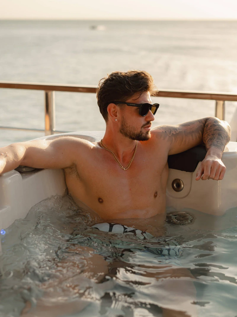 Man enjoying a relaxing jacuzzi experience aboard a luxury yacht with ocean views in the Andaman Sea