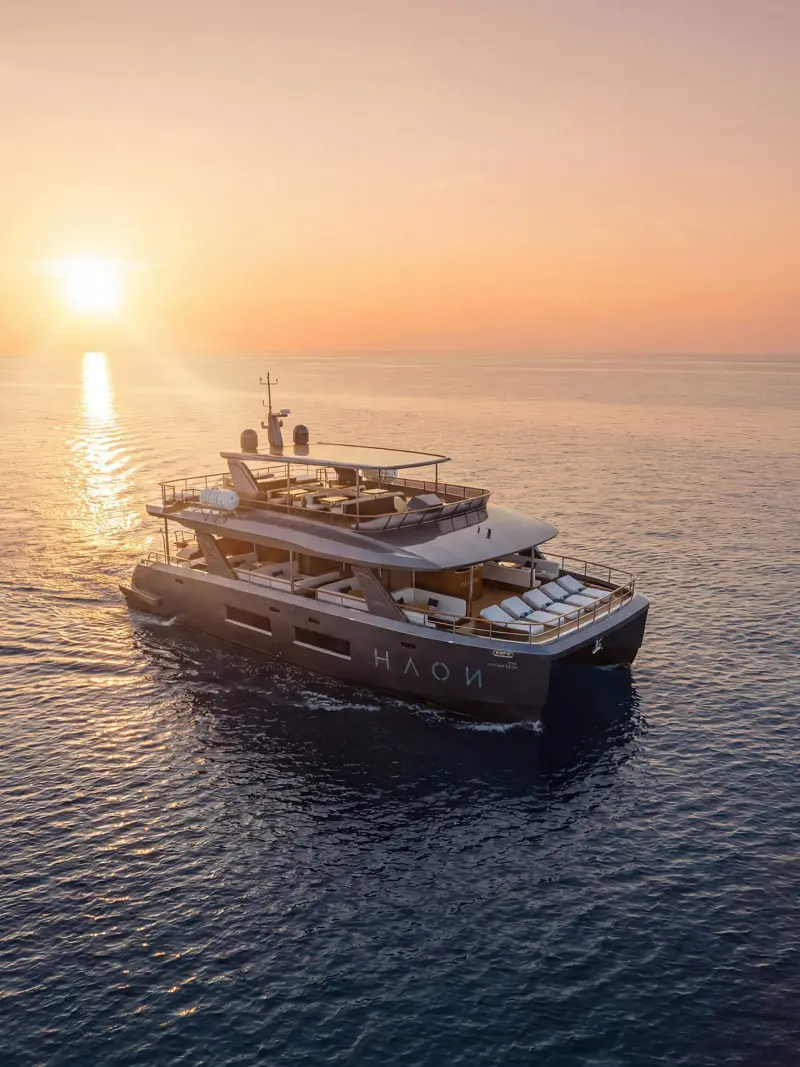 Luxury power catamaran yacht cruising across the Andaman Sea during a golden sunset on a Phi Phi and Maiton Islands tour from Phuket